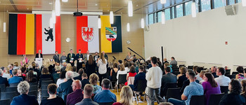 Finanzminister Michael Richter und Finanzstaatssekretär Rüdiger Malter überreichen Abschlusszeignisse an Absolventinnen und Absolventen der Fachhochschule für Finanzen in Königs Wusterhausen